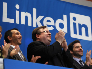 Reid Garrett Hoffman (center), the founder of LinkedIn, applauds from the bell balcony after the opening bell during the company's initial public offering at the New York Stock Exchange.
